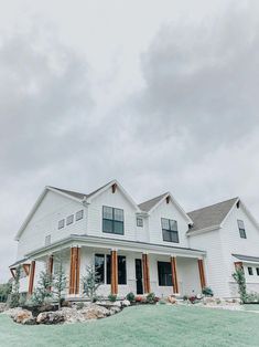 a large white house sitting on top of a lush green field