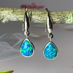 There is no need to look anywhere else when you can hold the entire Ocean Reef in your hands. Featuring a vivid and captivating Solid Black Peacock Blue Green Opal at the bottom, this stunning 9x7mm pear and teardrop shape Opal size dangling drop earrings will be the piece that will be the spotlight of your entire style. Encased in sleek and stylish sterling silver, you will win hearts and turn heads with this elegant piece of jewelry.  Key Features:  -Iridescent Hued Black Blue with Green Opal -Solid Sterling Silver  -Large Solid Created Opal -Fast Shipping -Limited Availability  Specifications:  -Total Weight 3g -Opal Total weight : 1.6 carats  -       Opal size: 9x7mm  -       Dangling hook earrings -       Adjustable 45+5cm Italian made silver necklace Shop now. Blue Pear-shaped Teardrop Earrings, Blue Gemstone Teardrop Earrings, Blue Pear-shaped Earrings For Gift, Blue Pear-shaped Jewelry As Gift, Blue Pear-shaped Jewelry Gift, Blue Pear-shaped Jewelry For Gifts, Black Peacock, Ocean Reef, Great Gifts For Women