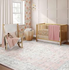 a baby's room with floral wallpaper and wooden furniture, including a crib