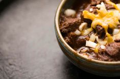 a bowl filled with chili and cheese on top of a table