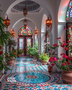 an ornate hallway with stained glass windows and potted plants on either side of the walkway