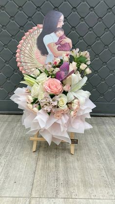 an arrangement of flowers in front of a wall with a photo on the top and bottom