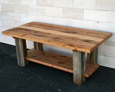 a wooden table sitting in front of a white brick wall with two shelves on each side