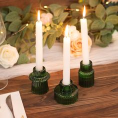 three candles sitting on top of a wooden table