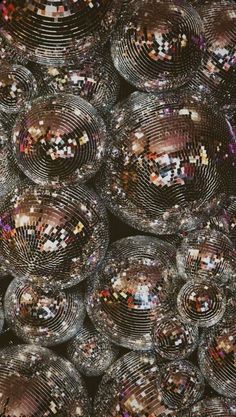 many shiny glass balls are stacked on top of each other in the middle of an image