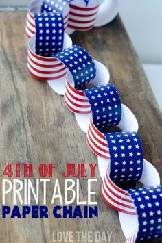 the fourth of july printable paper chain is displayed on a wooden table with an american flag ribbon