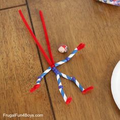 two red and blue toothbrushes sitting on top of a wooden table next to a white plate