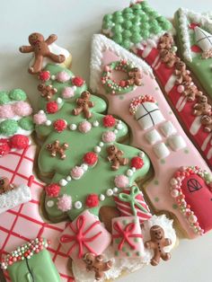 decorated cookies are arranged in rows on a white counter top, including christmas trees and stockings