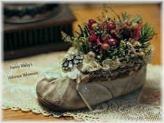 a pair of shoes that are sitting on a doily with flowers in the middle