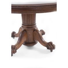 a close up of a wooden table with two hands on the base and one foot raised