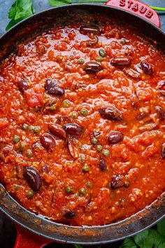 a large pot filled with lots of food on top of a red stovetop oven