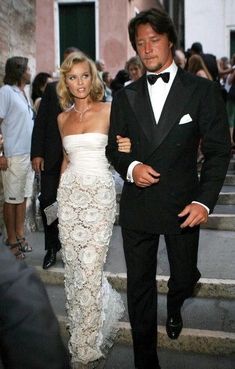 a man in a tuxedo walking next to a woman