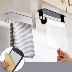 a kitchen storage rack with two towels hanging from it's sides and a hand holding a piece of paper