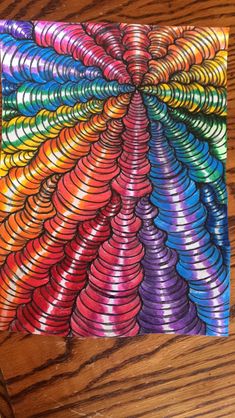 an image of a colorful spiral design on a piece of paper that has been drawn with colored pencils