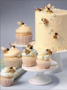 there are cupcakes with frosting and honeybees on the top one