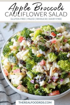 a bowl filled with broccoli, cauliflower and raisins sitting on top of a table