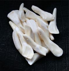 a pile of white toothpicks sitting on top of a black tableclothed surface