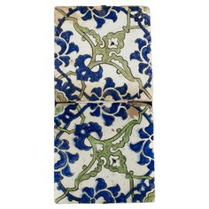 two blue and green tiles with flowers on them