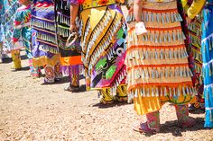 a group of people standing next to each other in front of a crowd wearing colorful clothing