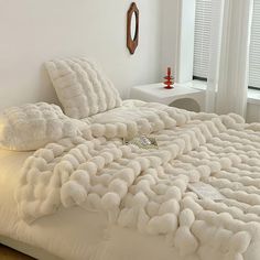 the bed is made with fluffy white blankets