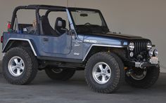 a blue jeep parked in front of a garage