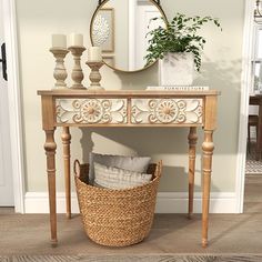 a wooden table with a basket on top of it next to a mirror and candles