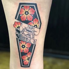 a woman's leg with flowers and a tattoo on the side of her leg