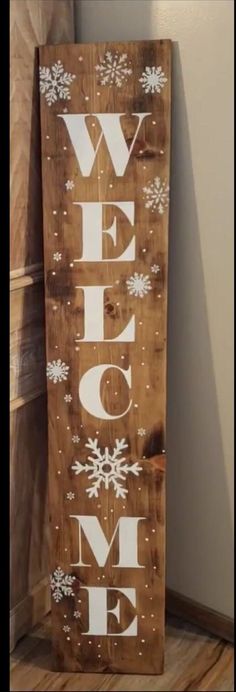 a wooden sign that says welcome home with snowflakes