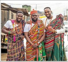 three men standing next to each other in colorful clothing