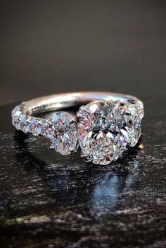 an engagement ring with three stone diamonds on the side and one diamond in the middle