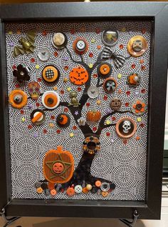 a black frame with an orange and white tree on it that has buttons all over it