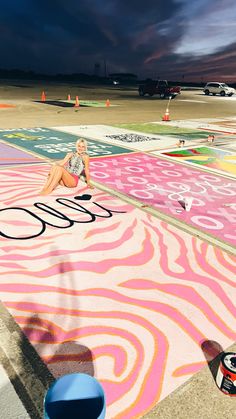 a woman sitting on top of a colorful rug