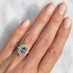 a woman's hand with an engagement ring on her finger, and the center stone is