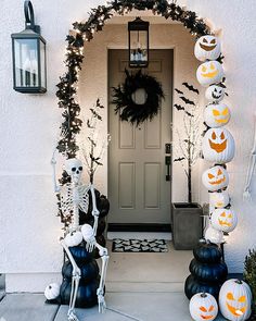 halloween decorations on the front door of a house with pumpkins and jack - o'- lanterns