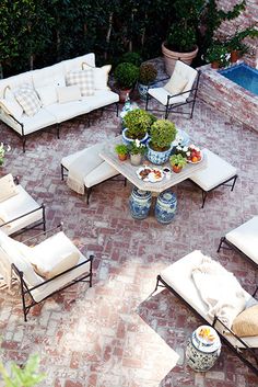 an aerial view of a patio with couches, tables and potted plants on it