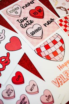 valentine's day cards are arranged on a red tablecloth with hearts and checkered paper