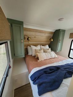 a bed with pillows and blankets in a small room