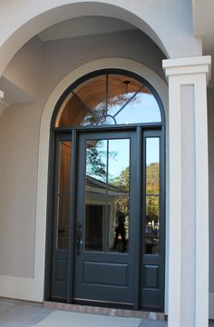 the front door to a house with an arched glass window