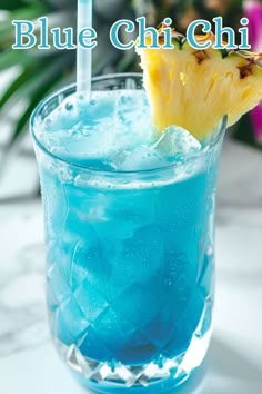 a blue drink with a pineapple slice on the rim and ice in front of it