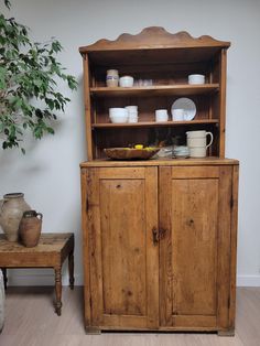 an old wooden cabinet with dishes on it