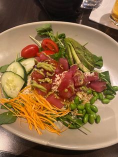 a white plate topped with lots of veggies and meat on top of it