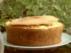 a cake sitting on top of a white plate next to a green bush in the background