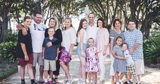 a family poses for a photo in front of some trees