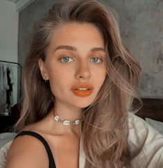 a woman with orange lipstick on her lips