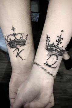 two people holding hands with tattoos on their arms and one has a crown tattooed on the wrist