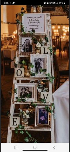 an old ladder is decorated with photos and greenery for a wedding or special event