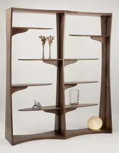 a wooden shelf with two vases on top and one glass in the bottom section