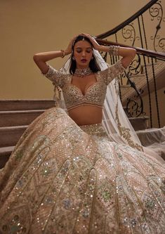 a woman in a wedding dress sitting on the stairs with her hands behind her head