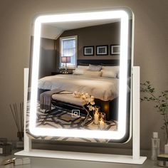 a bedroom with a large lighted mirror on the wall and a bed in the reflection