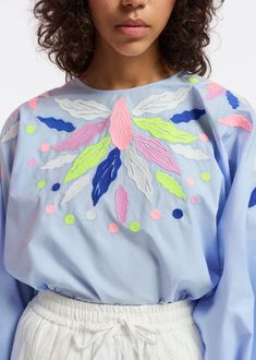 Top is cut from a crisp cotton-poplin decorated with colorful embroideries. the style is detailed with voluminous sleeves that fall to elasticated cuffs and a round neckline.    - 100% cotton  - lightweight non-stretchy fabric  - intended for an oversized fit  - hidden zip fastening at the back  - voluminous sleeves with elasticated cuffs  - embroidery details  - light blue/dark blue/lime green    fabric    100% cotton  embroidery: 100% polyester    washing instructions    machine washable Blue Bishop Sleeve Blouse For Spring, Embroidered Bishop Sleeve Cotton Top, Embroidered Cotton Bishop Sleeve Top, Cotton Blouse With Embroidered Bishop Sleeves, Spring Blue Geometric Embroidered Blouse, Summer Embroidered Top With Blouson Sleeves, Long Sleeve Embroidered Top For Summer, Spring Embroidered Balloon Sleeve Blouse, Spring Embroidered Blouse With Balloon Sleeves